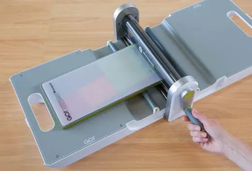 A person using the paper cutter to cut papers.