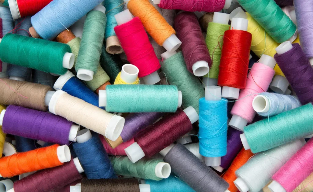 A pile of different colored sewing thread.